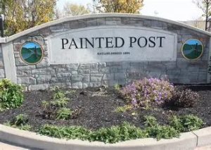Village of Painted Post stone wall with rounded top setting inside a mulched flower bed